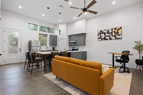 a living room with furniture kitchen view and a window