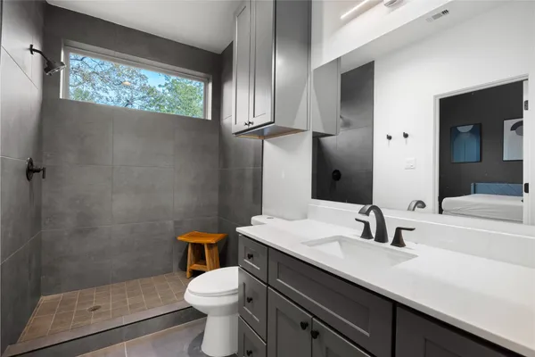 a bathroom with a sink a toilet and shower