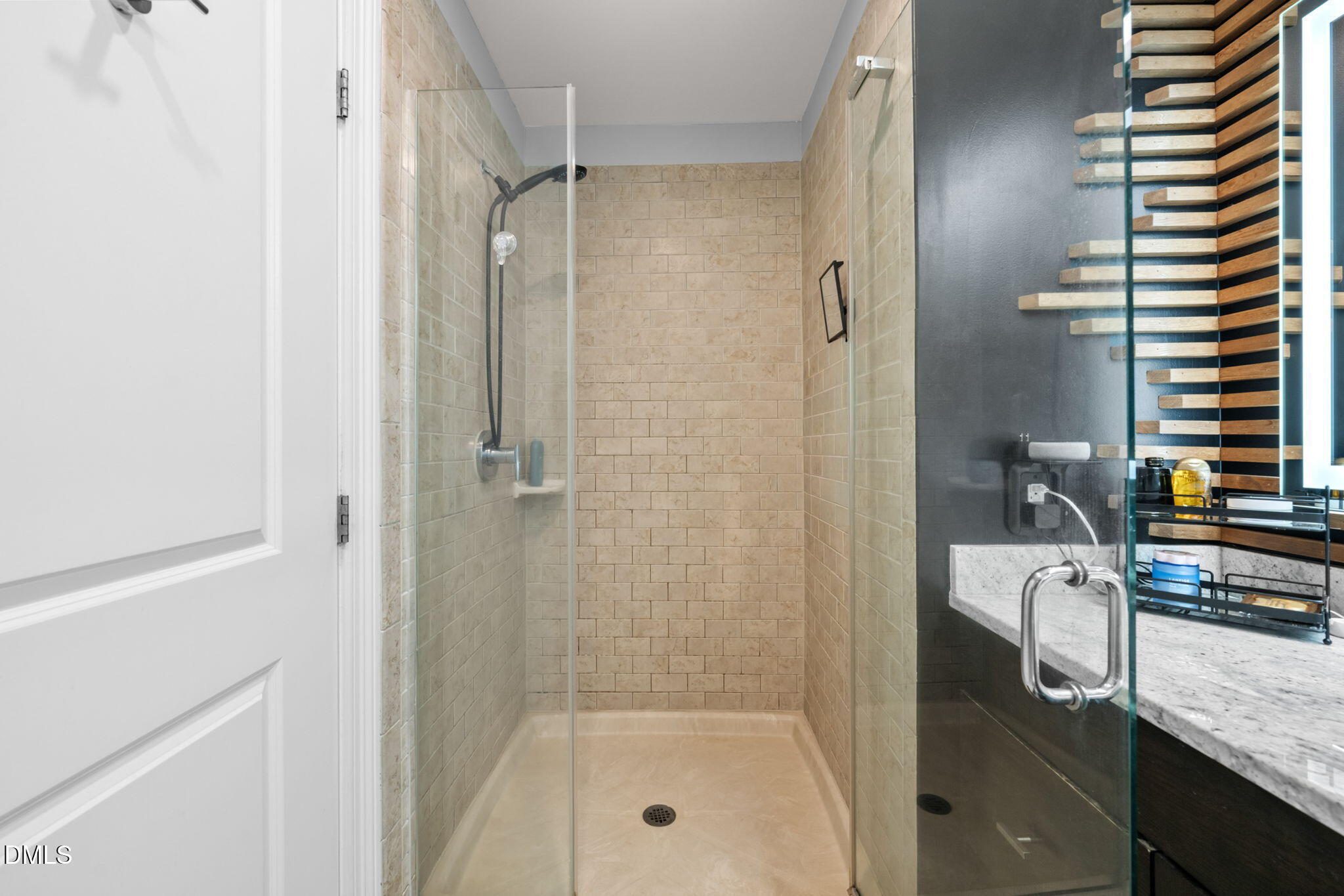 400 West North Street, Unit 1218 Raleigh, NC 27603 - Photo 23 of 41 a bathroom with a granite countertop sink a mirror and a shower