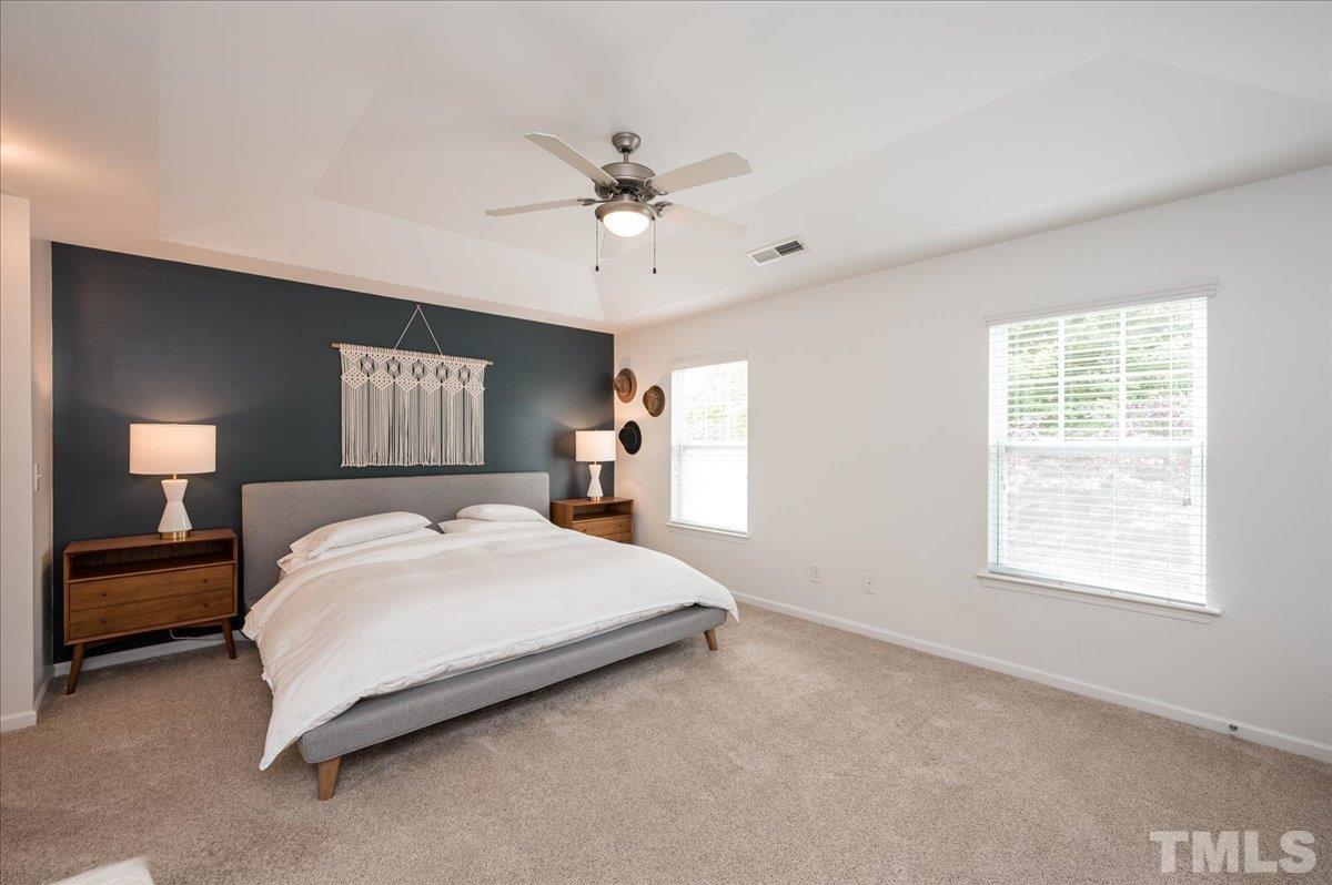 2405 Swans Rest Way Raleigh, NC 27606 - Photo 16 of 29 a bedroom with a bed and a chandelier