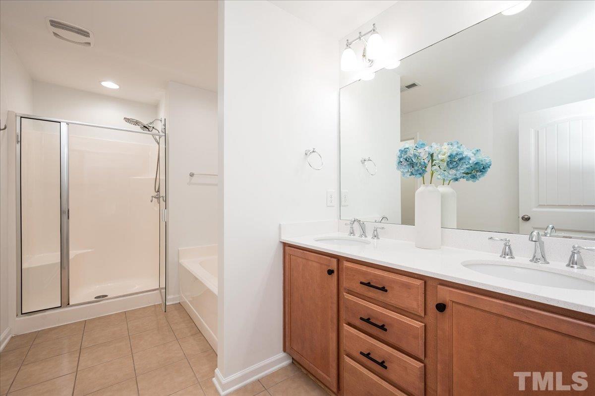 2405 Swans Rest Way Raleigh, NC 27606 - Photo 18 of 29 a bathroom with a granite countertop sink a mirror and a shower