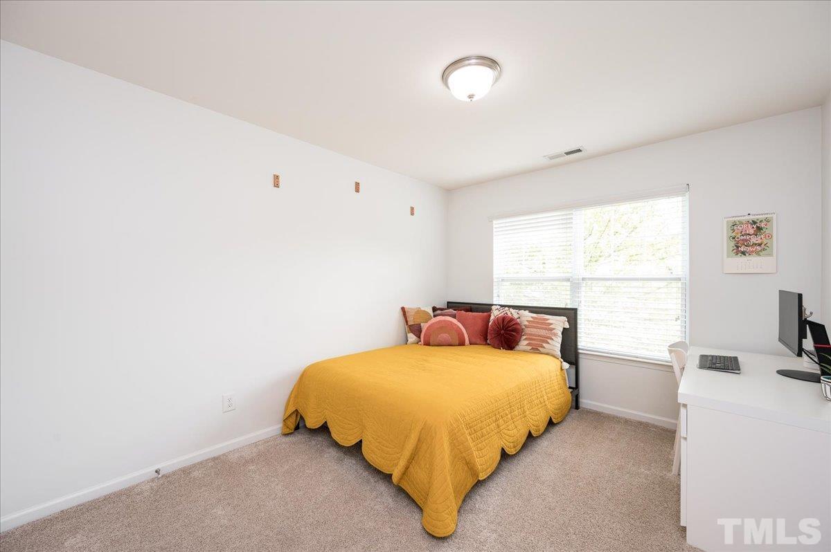 2405 Swans Rest Way Raleigh, NC 27606 - Photo 21 of 29 a bedroom with a bed and a large window