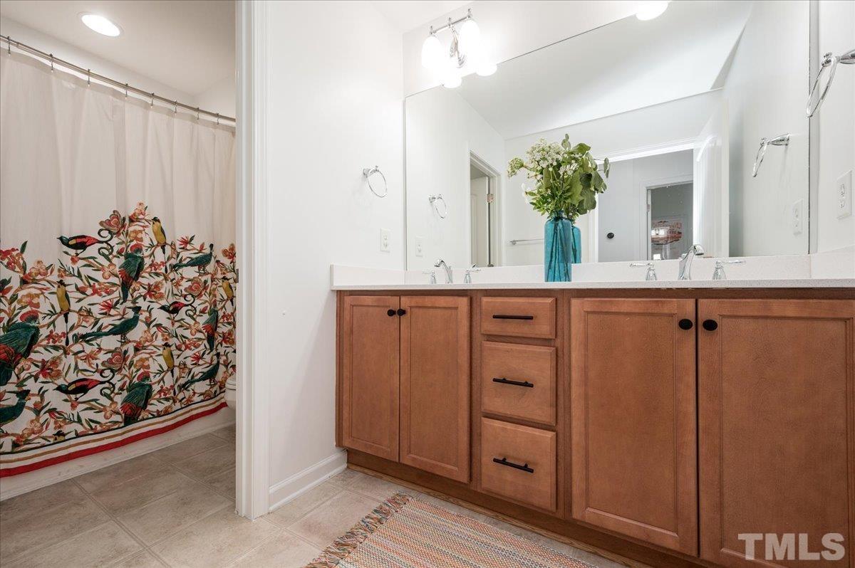 2405 Swans Rest Way Raleigh, NC 27606 - Photo 22 of 29 a bathroom with a sink and a mirror