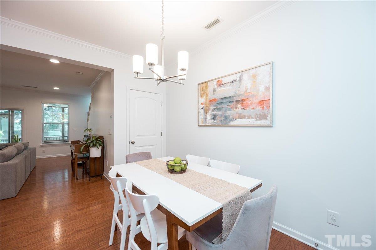 2405 Swans Rest Way Raleigh, NC 27606 - Photo 5 of 29 a view of a dining room with furniture a chandelier and wooden floor