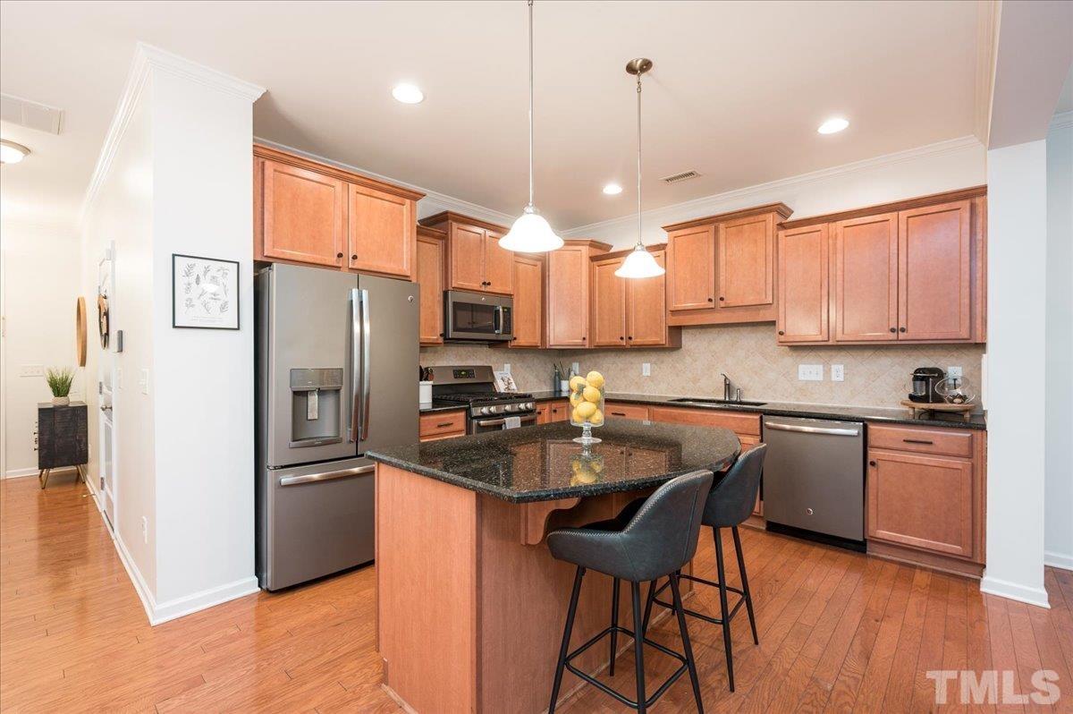 2405 Swans Rest Way Raleigh, NC 27606 - Photo 7 of 29 a kitchen with stainless steel appliances granite countertop a refrigerator a sink a stove a dining table and chairs
