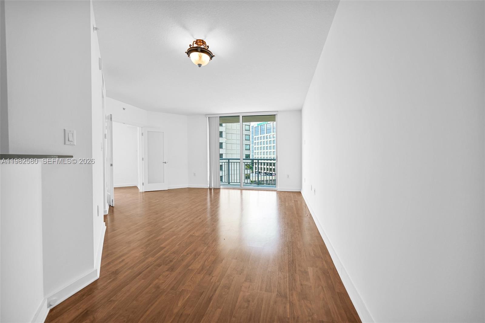 9055 Southwest 73rd Court, Unit 1104 Miami, FL 33156 - Photo 4 of 19 wooden floor in an empty room with a window