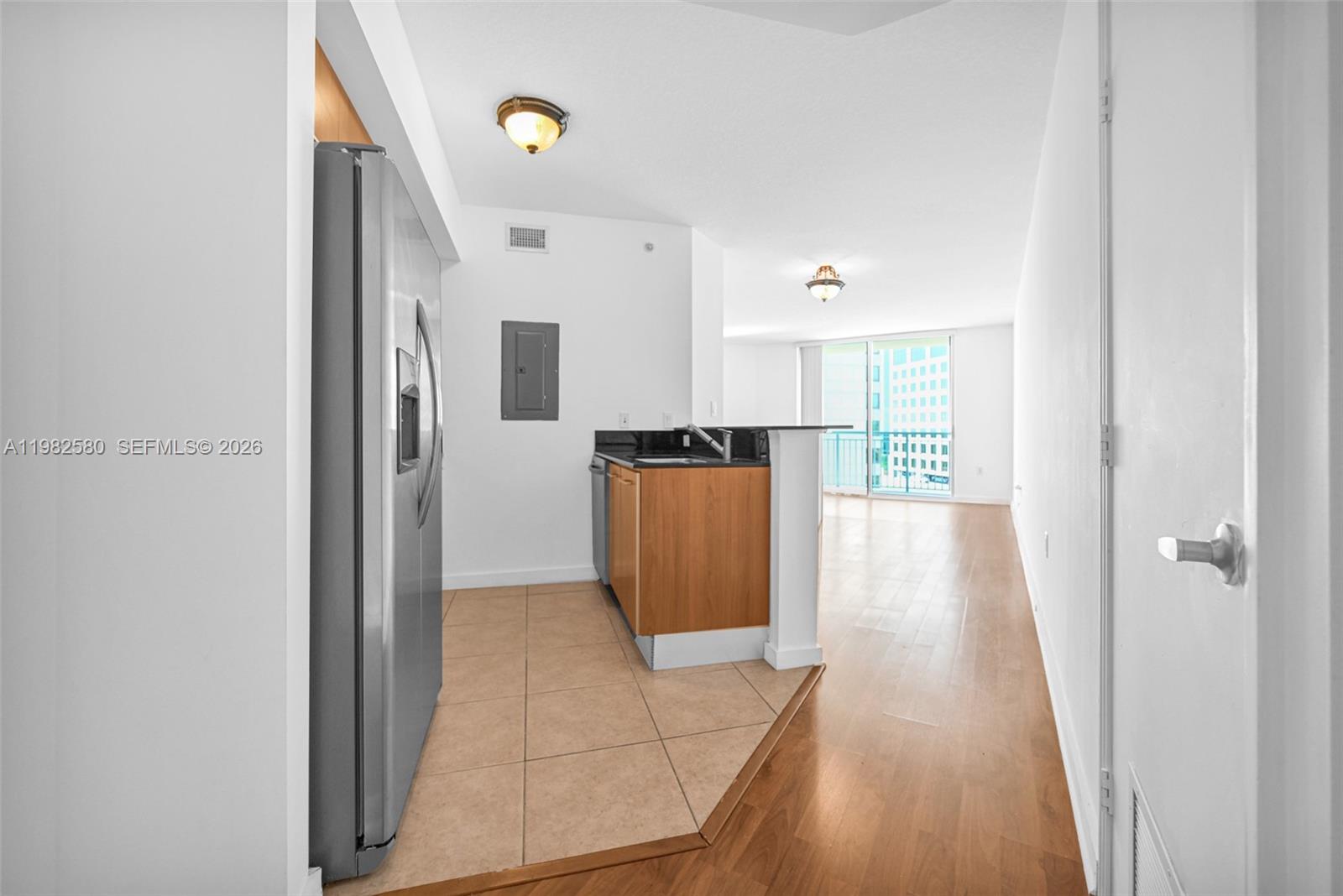 9055 Southwest 73rd Court, Unit 1104 Miami, FL 33156 - Photo 10 of 19 a view of a refrigerator in kitchen and an empty room
