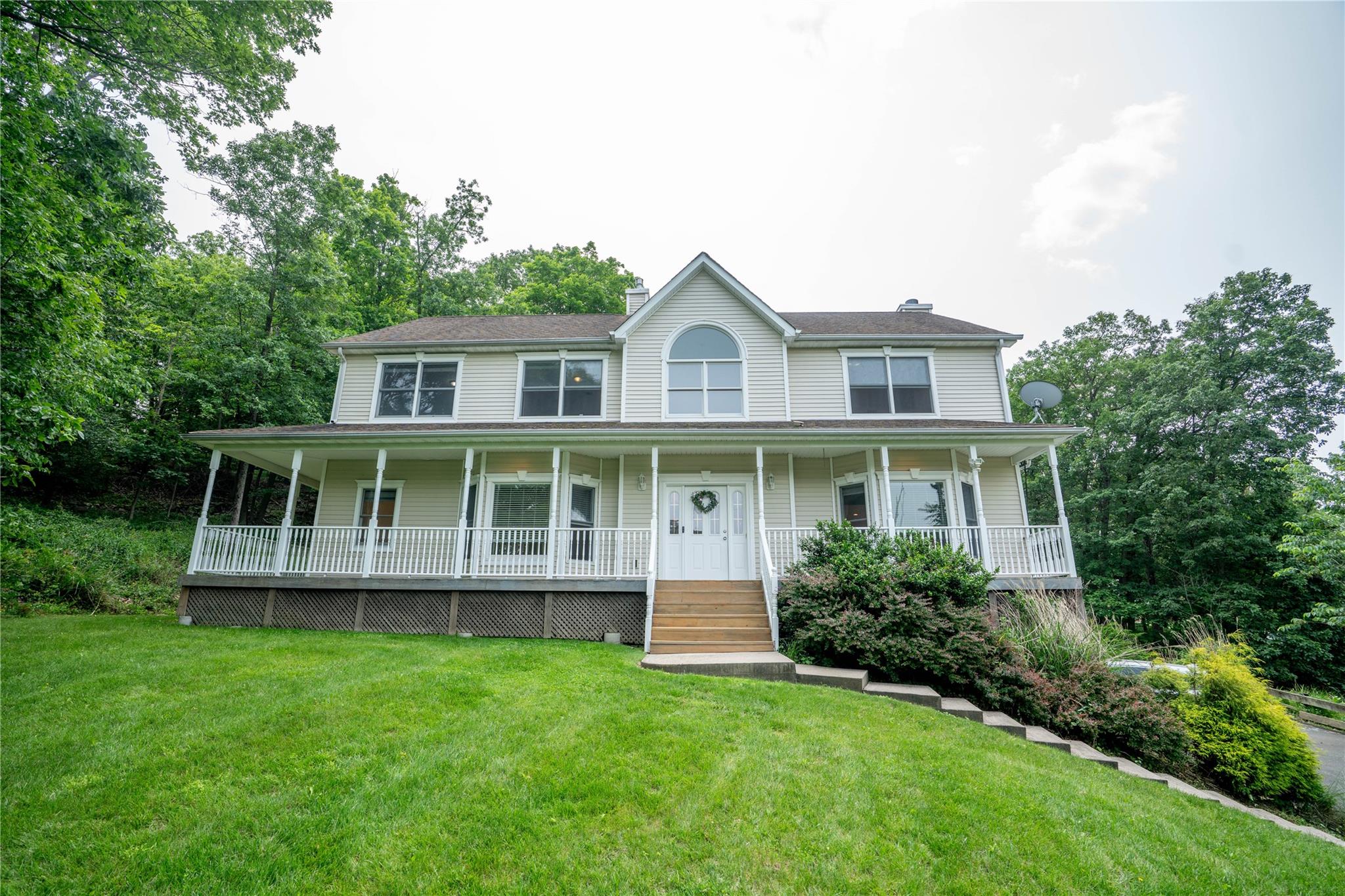 View of front of property featuring a porch, a chimney, and a front yard