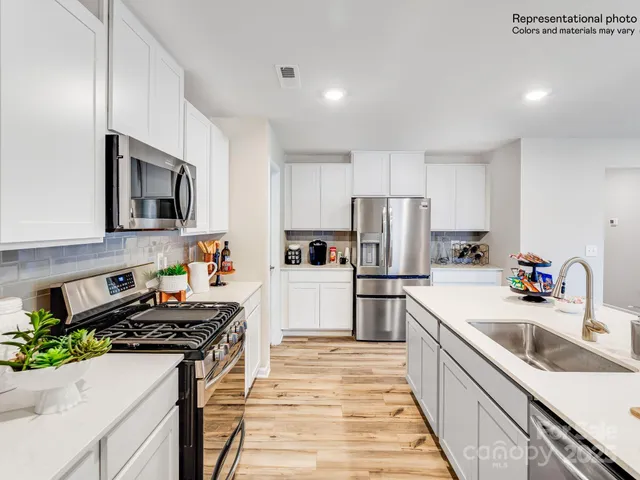a view of a kitchen area with furniture and wooden floor