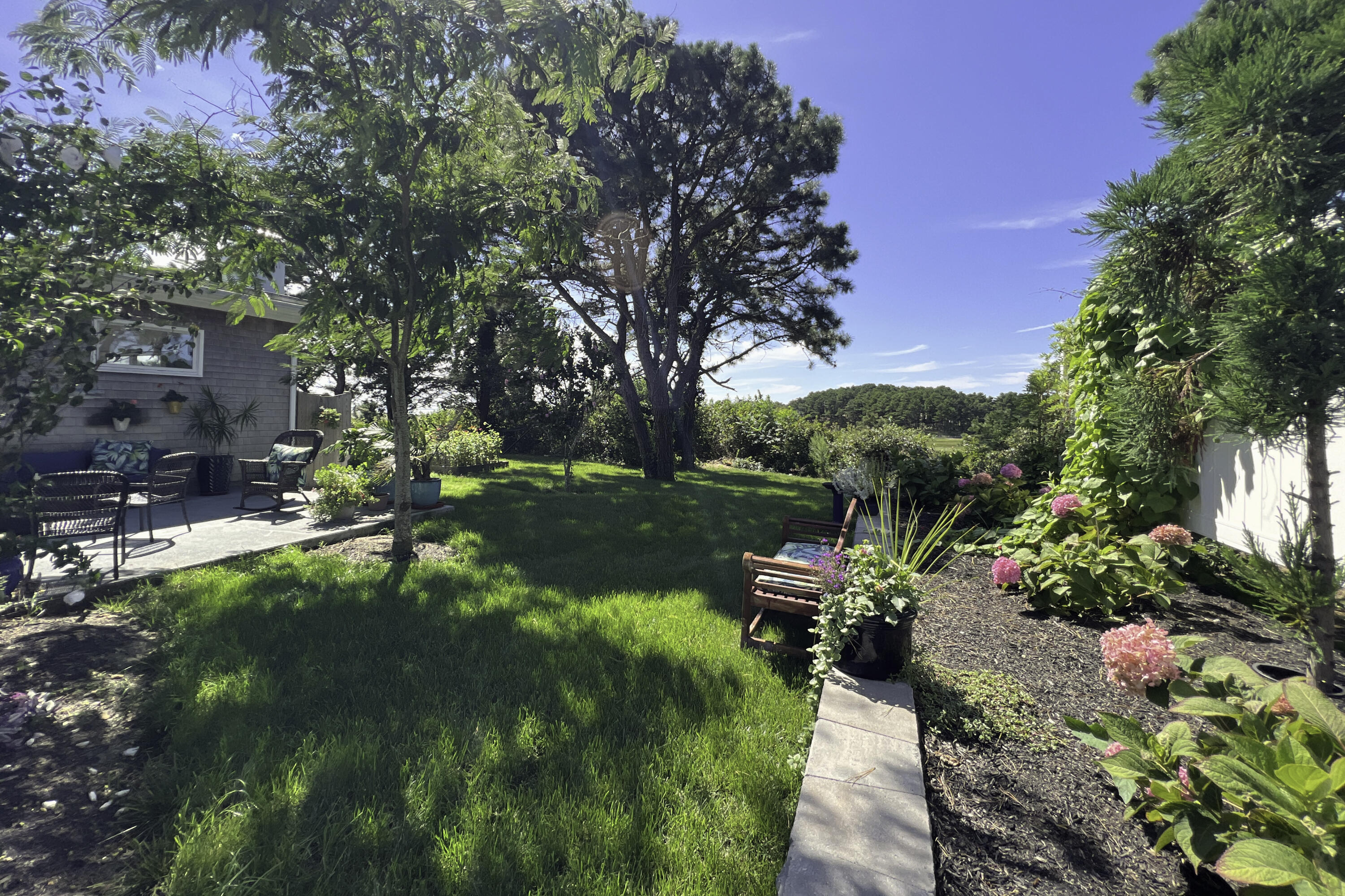 60 5th Avenue Wellfleet, MA 02667 - Photo 8 of 42 a backyard of a house with a garden and outdoor seating
