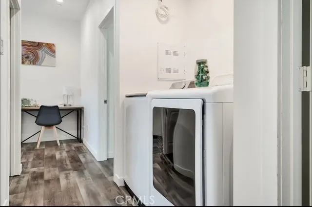 a bedroom with a bed a couch and a flat tv screen on the dresser