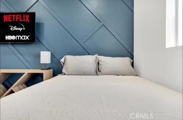 a bedroom with a bed and a painting on the wall