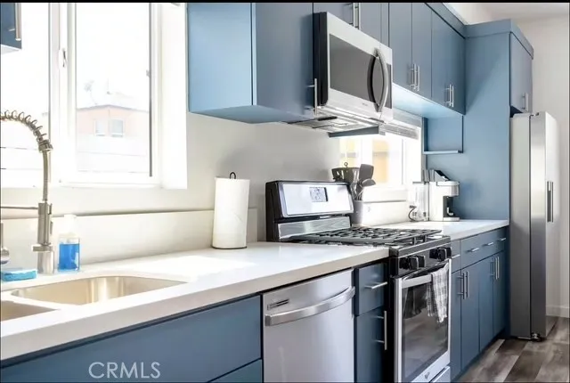 a kitchen with stainless steel appliances granite countertop a sink stove and microwave