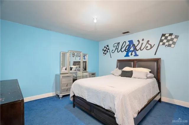 a bedroom with a bed a dresser and a large window