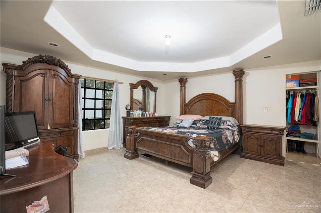 1608 Corales Street Mission, TX 78573 - Photo 18 of 29 a bedroom with a bed next to a desk with bookshelf and a window