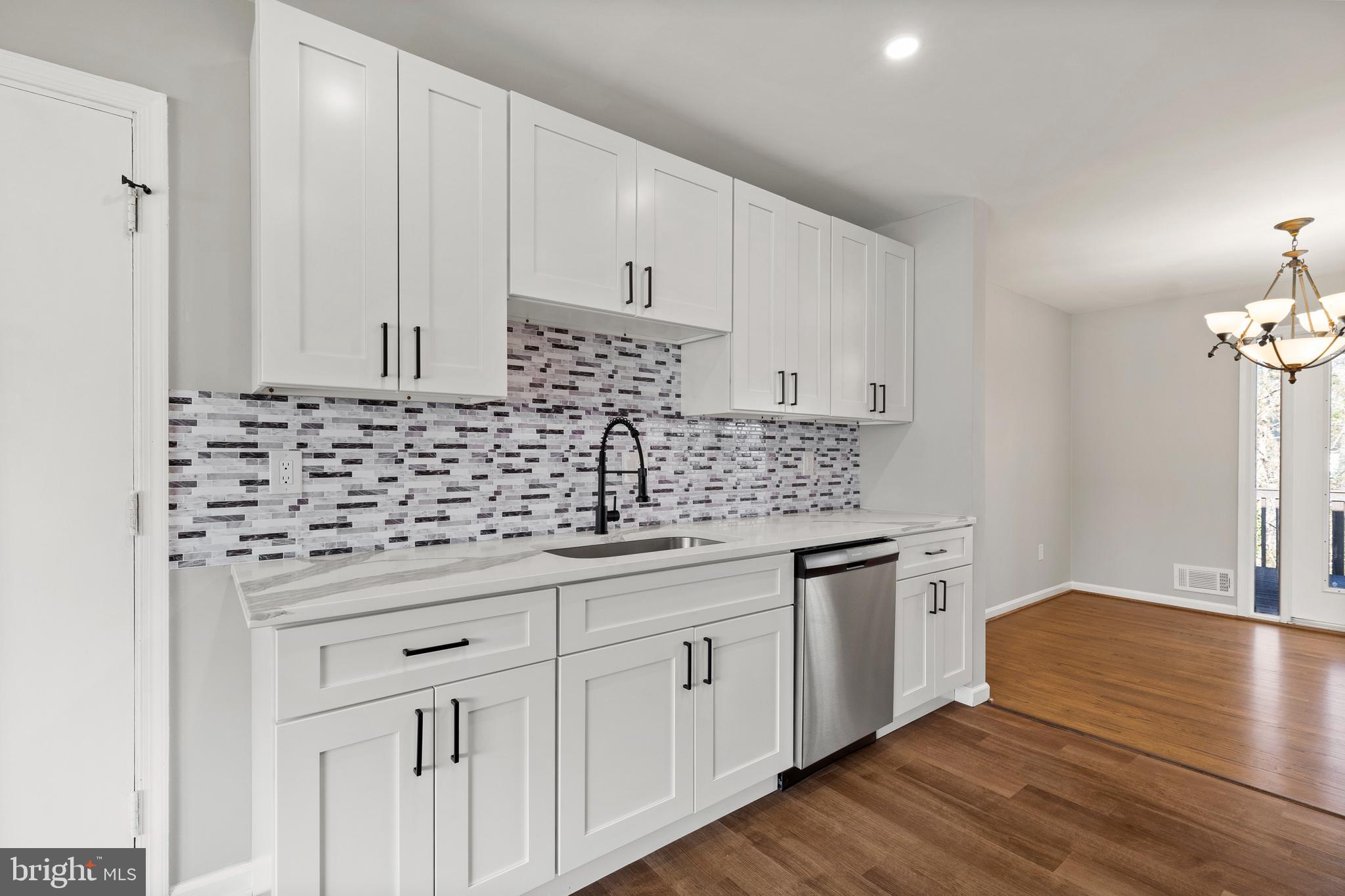 7517 Todd Place Manassas, VA 20109 - Photo 22 of 42 a kitchen with granite countertop white cabinets and white appliances