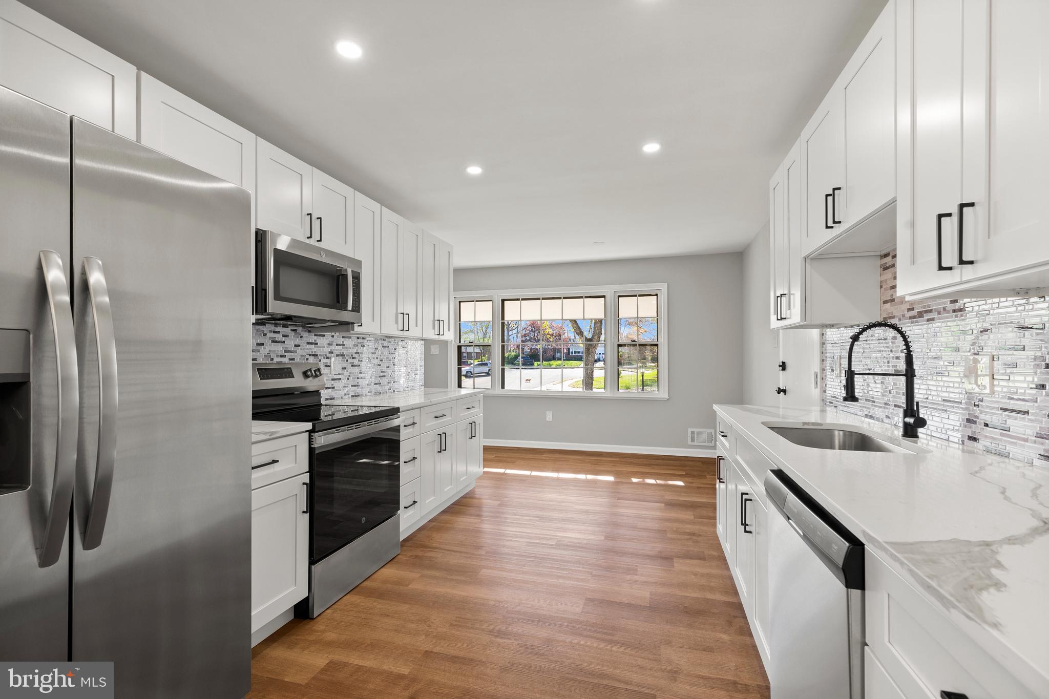 7517 Todd Place Manassas, VA 20109 - Photo 23 of 42 a large kitchen with stainless steel appliances granite countertop a lot of counter space and wooden floor