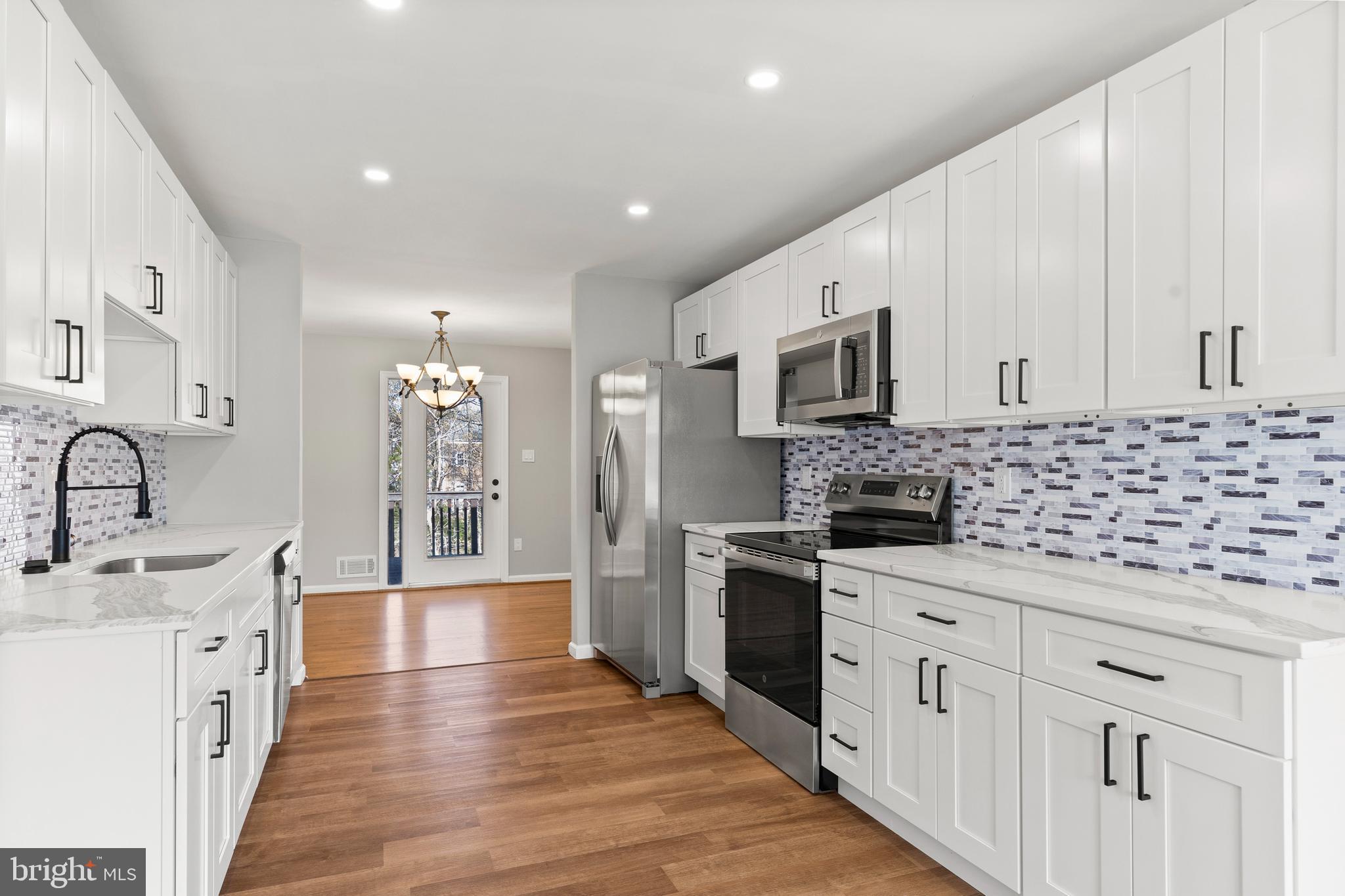 7517 Todd Place Manassas, VA 20109 - Photo 5 of 42 a large kitchen with stainless steel appliances kitchen island granite countertop a sink and cabinets