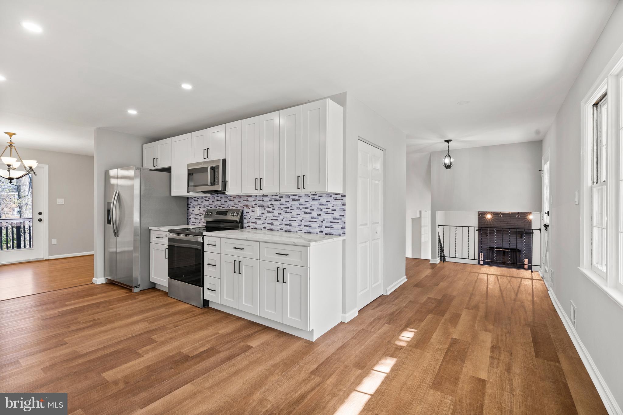 7517 Todd Place Manassas, VA 20109 - Photo 6 of 42 a large white kitchen with stainless steel appliances granite countertop a stove and a refrigerator