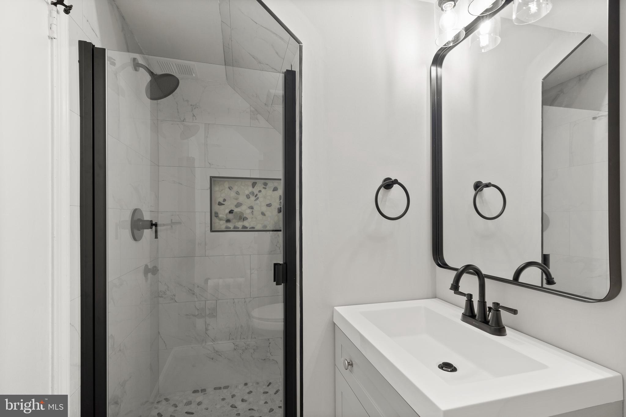 7517 Todd Place Manassas, VA 20109 - Photo 8 of 42 a bathroom with a shower sink and mirror