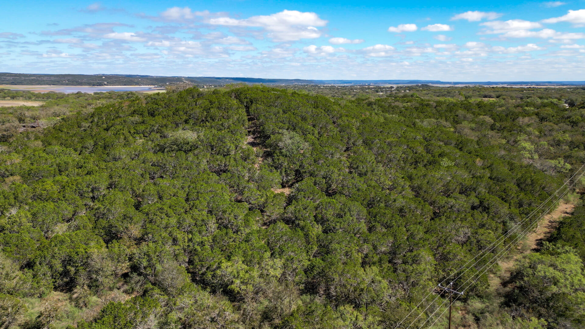0 Ranch Road 2241 Tow, TX 78672 - Photo 15 of 33 Vast green acreage extends towards the distant lake under an open sky.