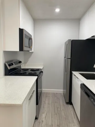 a kitchen with a refrigerator and a stove top oven