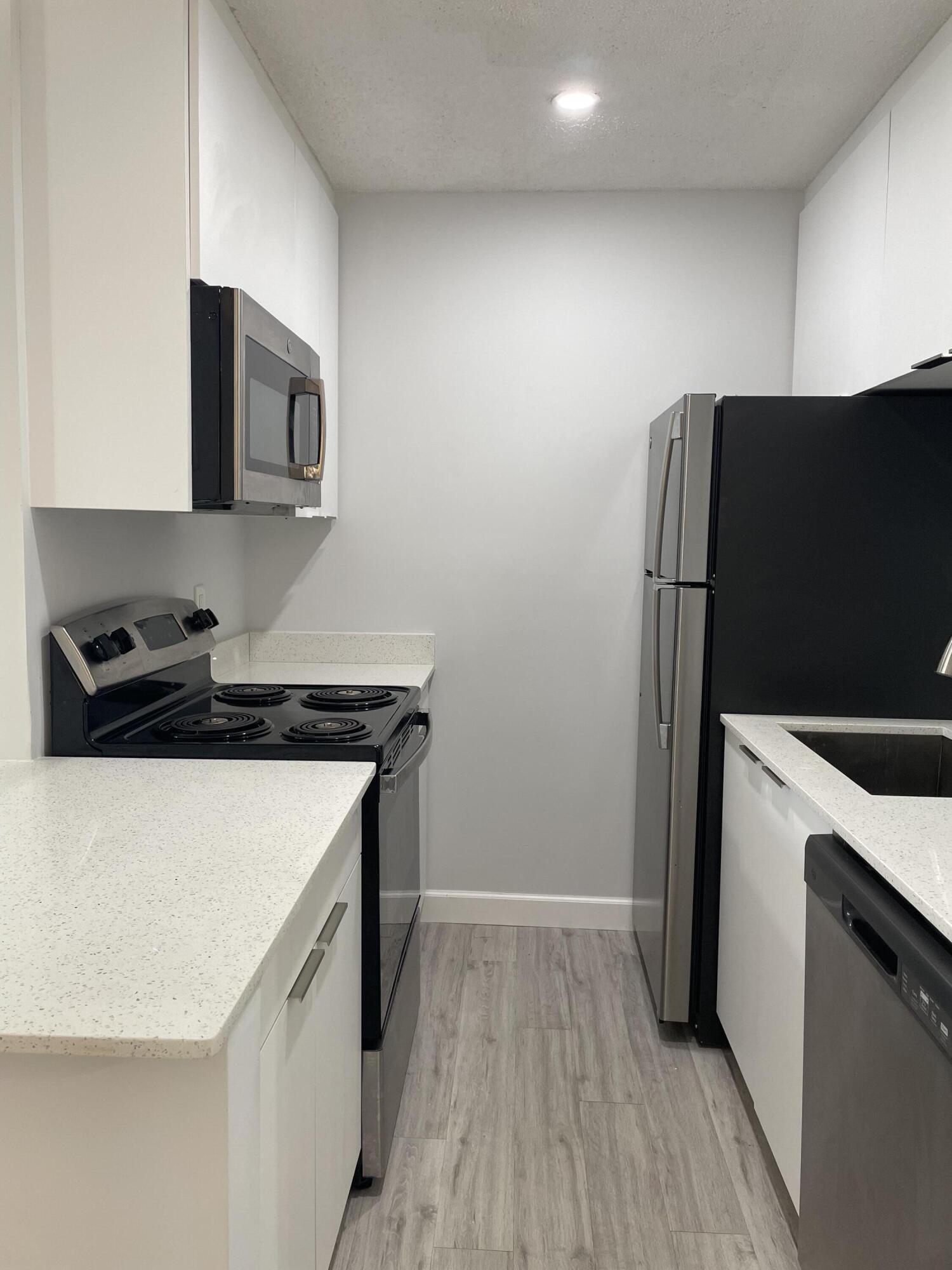 3 Crossings Circle, Unit A Boynton Beach, FL 33435 - Photo 13 of 21 a kitchen with a refrigerator and a stove top oven