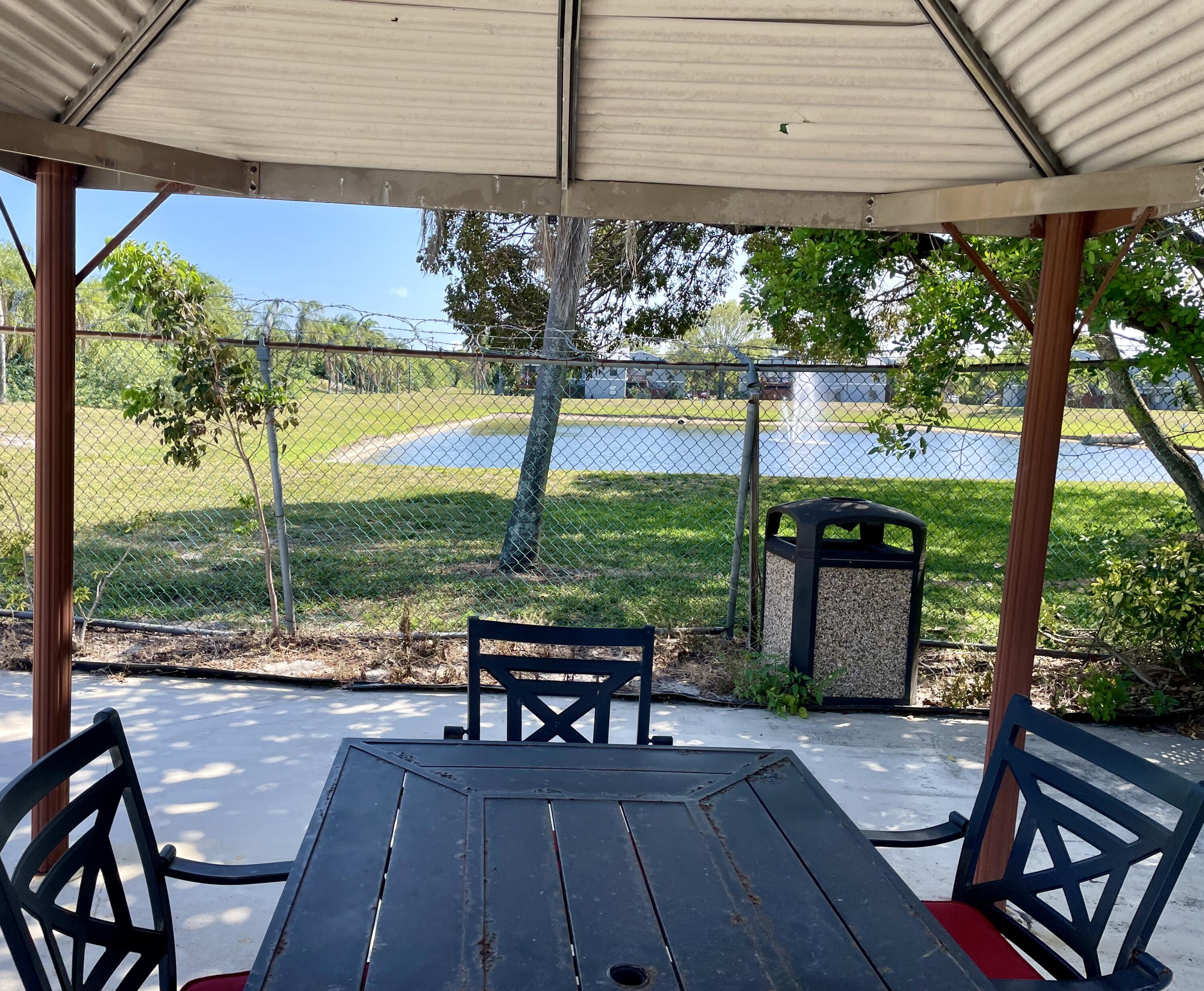 3 Crossings Circle, Unit A Boynton Beach, FL 33435 - Photo 18 of 21 a view of a chairs and table in the patio with a fire pit