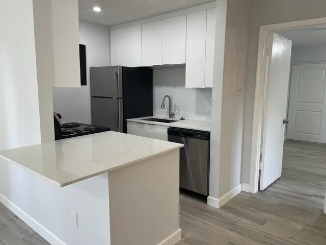 a kitchen with kitchen island a sink a stove and refrigerator