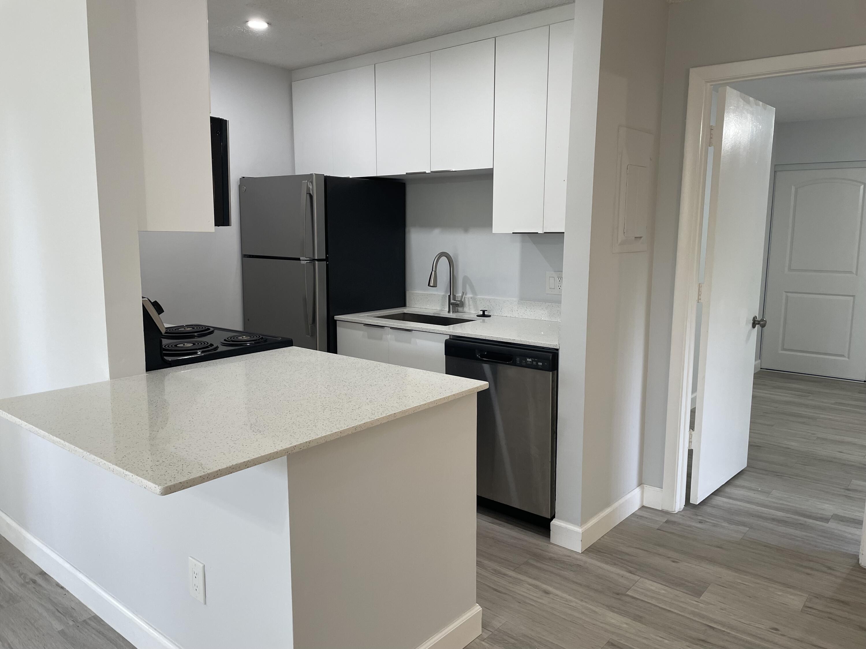3 Crossings Circle, Unit A Boynton Beach, FL 33435 - Photo 3 of 21 a kitchen with kitchen island a sink a stove and refrigerator