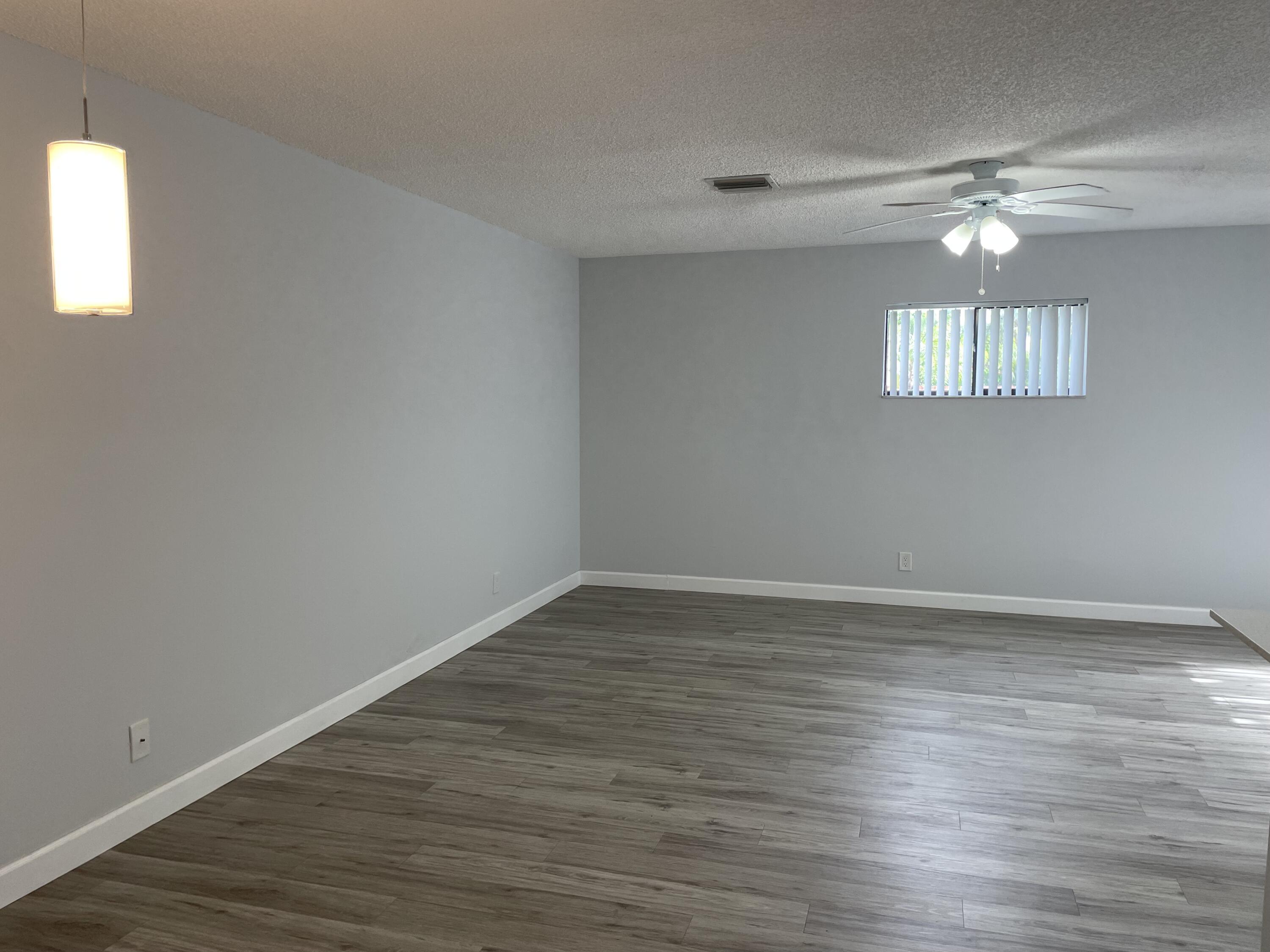 3 Crossings Circle, Unit A Boynton Beach, FL 33435 - Photo 4 of 21 a view of an empty room with wooden floor and a window