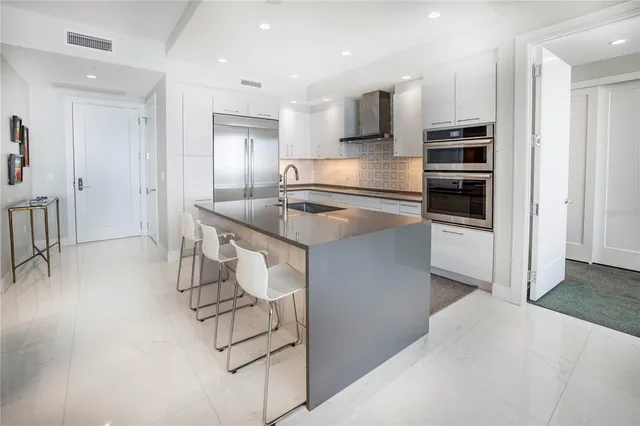 a kitchen with stainless steel appliances kitchen island granite countertop a sink and cabinets