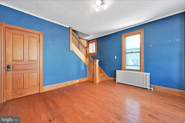 a view of an empty room with wooden floor