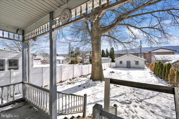 a view of a white house with wooden fence