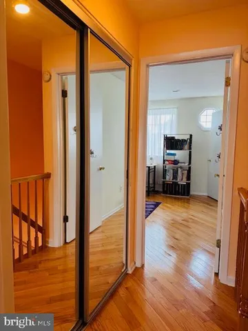 a view of a hallway with wooden floor and dining room view