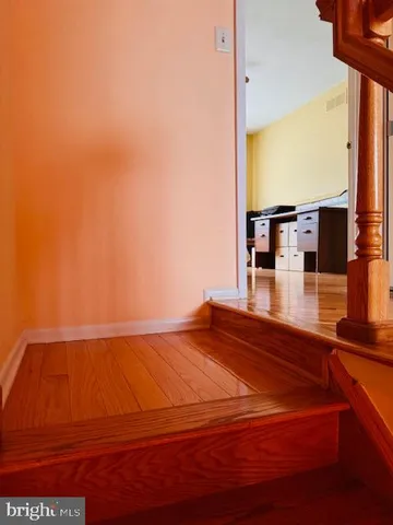 a view of a hallway with wooden floor and closet