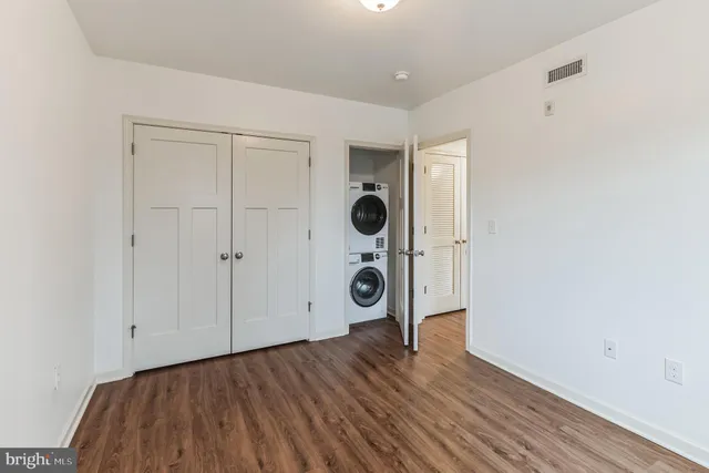 an empty room with closet and wooden floor