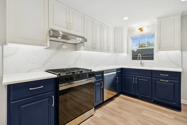 a kitchen with stainless steel appliances granite countertop a stove a sink and a microwave