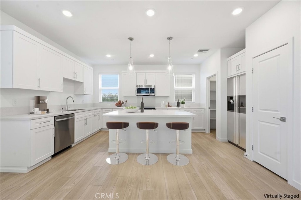 9335 Via Azul Pico Rivera, CA 90660 - Photo 12 of 55 a kitchen with a sink a refrigerator and white cabinets
