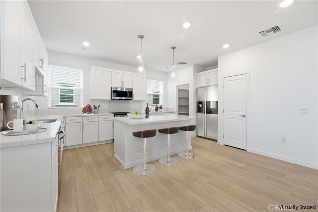 9335 Via Azul Pico Rivera, CA 90660 - Photo 14 of 55 a kitchen with white cabinets and stainless steel appliances