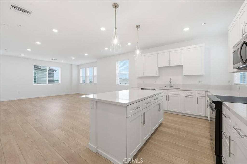 9335 Via Azul Pico Rivera, CA 90660 - Photo 15 of 55 a large kitchen with stainless steel appliances granite countertop a stove a sink a refrigerator and white cabinets with wooden floor