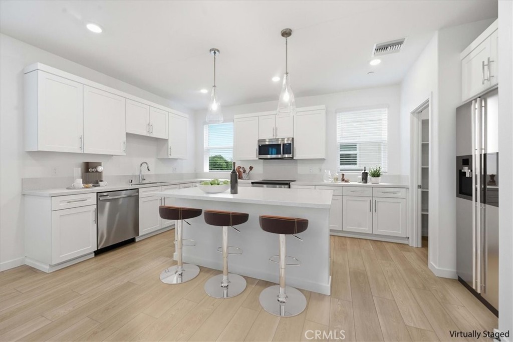 9335 Via Azul Pico Rivera, CA 90660 - Photo 10 of 55 a kitchen with white cabinets stainless steel appliances and kitchen island