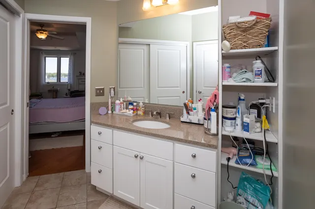 a bathroom with a granite countertop toilet sink and mirror