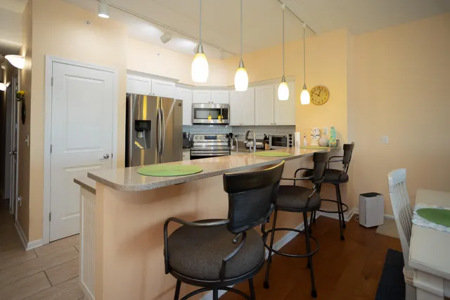 a kitchen with stainless steel appliances granite countertop a sink refrigerator and cabinets