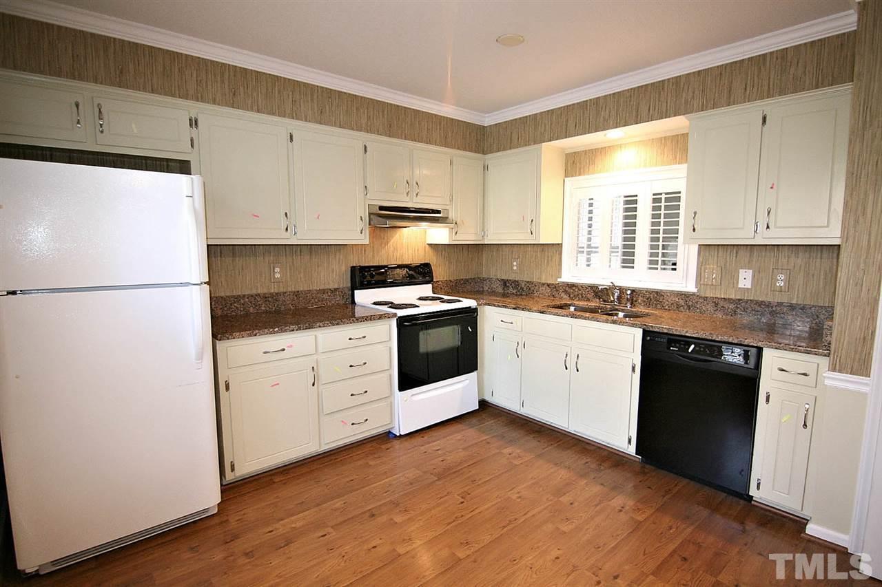 1581 Laureldale Drive Raleigh, NC 27609 - Photo 6 of 21 a kitchen with granite countertop white cabinets and white appliances