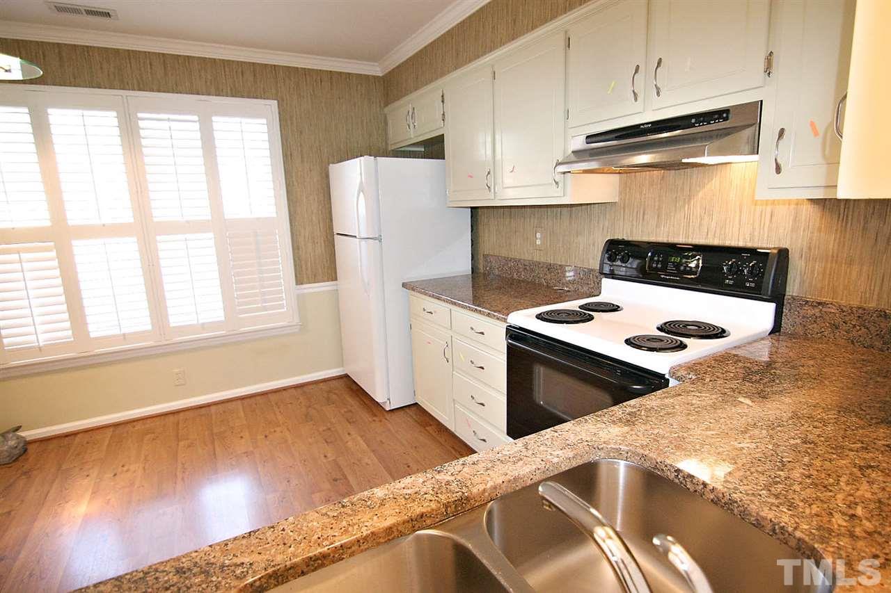 1581 Laureldale Drive Raleigh, NC 27609 - Photo 7 of 21 a kitchen with a stove a refrigerator and a white cabinets