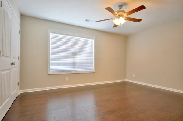 an empty room with a window and a fan
