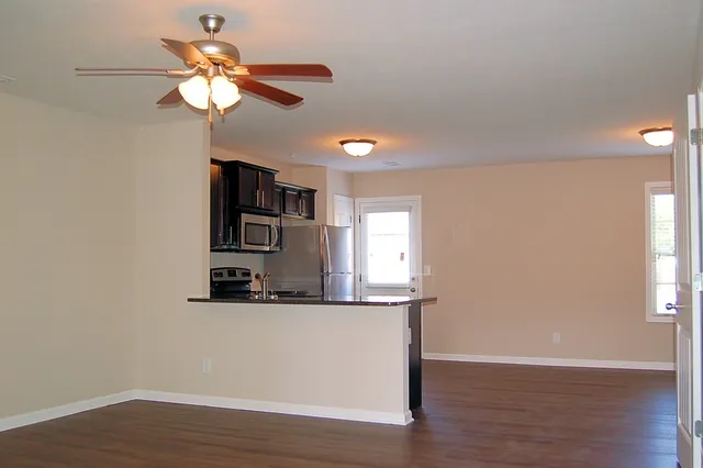a view of a kitchen with a sink a cabinet and wooden floor