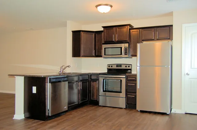 a kitchen with granite countertop stainless steel appliances and wooden cabinets