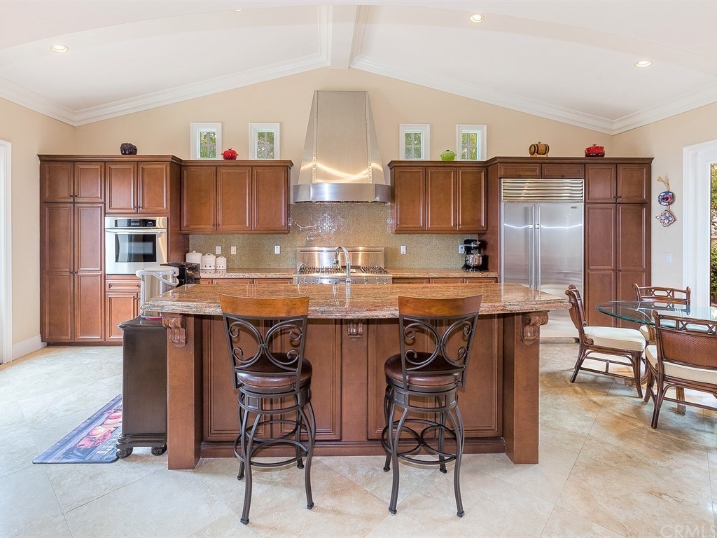 26 Tideline Bluff Newport Coast, CA 92657 - Photo 16 of 31 a kitchen with stainless steel appliances granite countertop a table chairs sink refrigerator and cabinets
